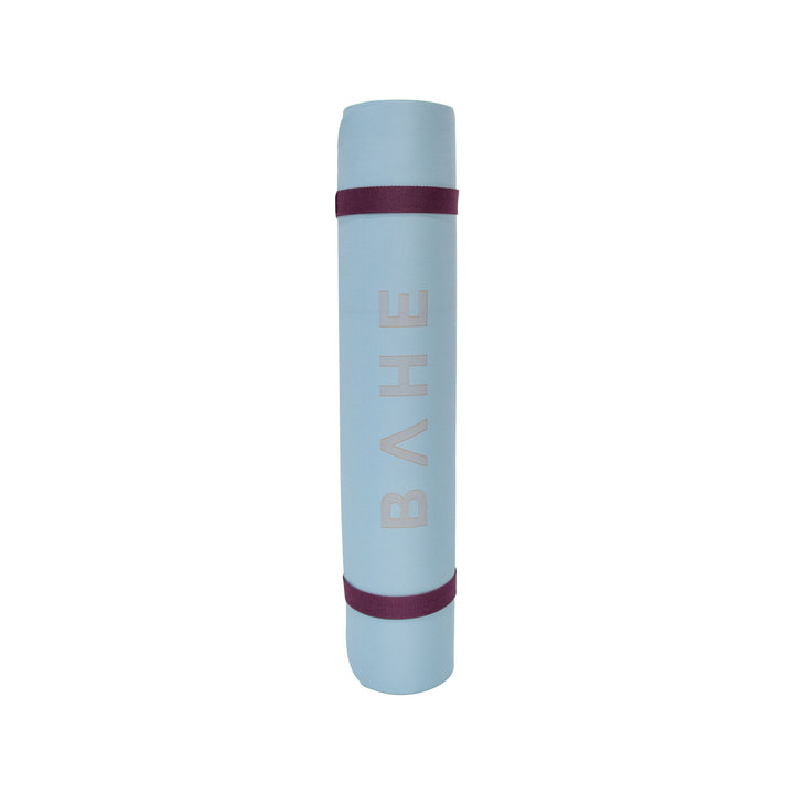 Bahe blue yoga mat rolled up, standing up