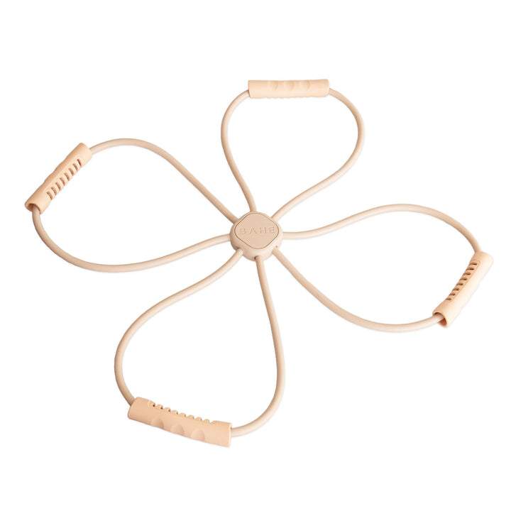 A beige four-loop resistance band exerciser with textured foam handles and a central hub, shown on a plain white background.