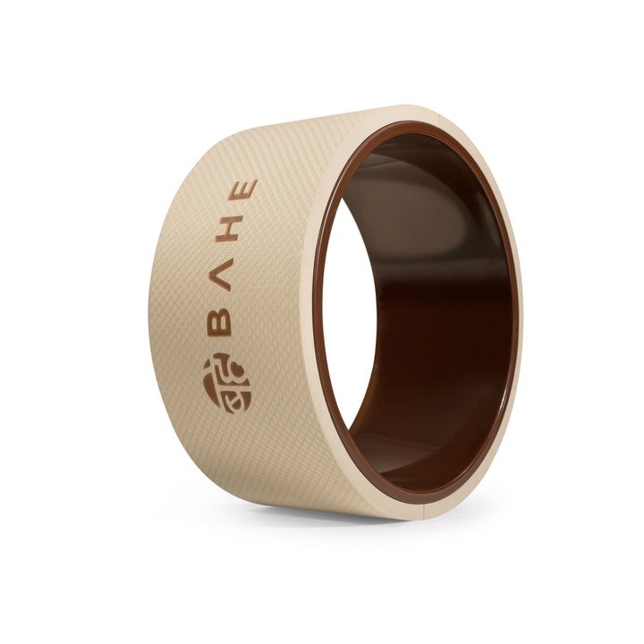 A beige yoga wheel with the brand name &